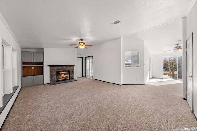 unfurnished living room featuring a fireplace, light carpet, plenty of natural light, and a baseboard heating unit