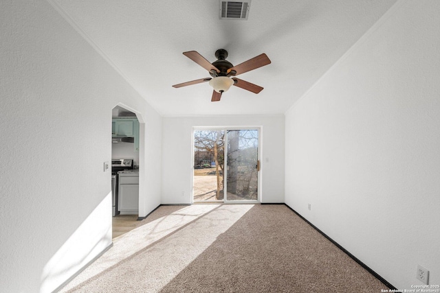 carpeted spare room featuring ceiling fan