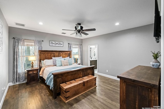 bedroom with multiple windows, ensuite bathroom, ceiling fan, and dark hardwood / wood-style floors