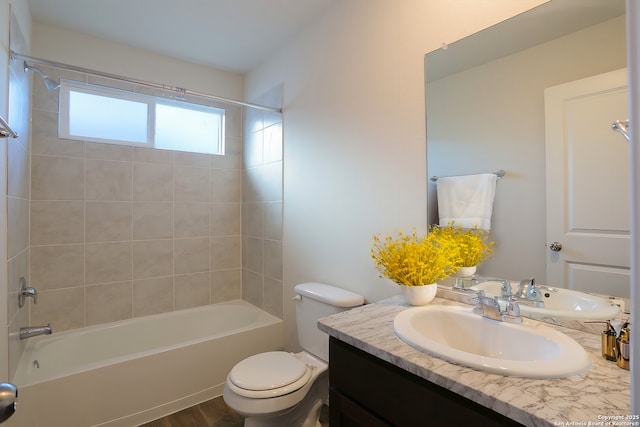 full bathroom with hardwood / wood-style floors, vanity, toilet, and tiled shower / bath