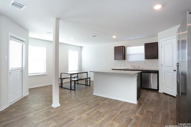 kitchen featuring dark hardwood / wood-style flooring, dark brown cabinetry, dishwasher, and a center island