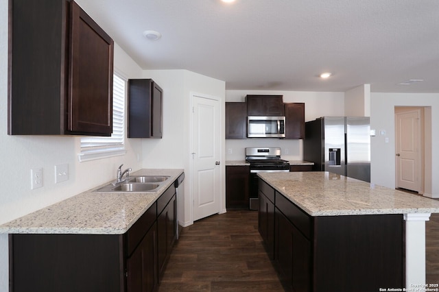 kitchen featuring sink, a kitchen island, dark brown cabinets, and appliances with stainless steel finishes