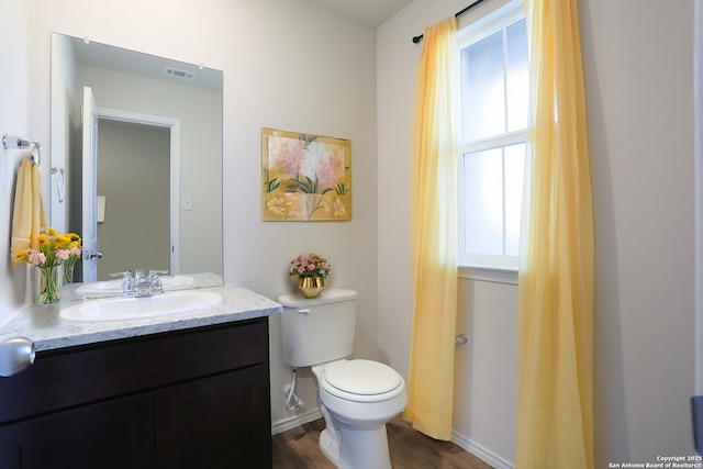 bathroom with toilet, vanity, and hardwood / wood-style flooring