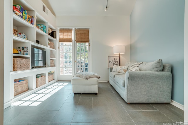 living area featuring rail lighting and french doors