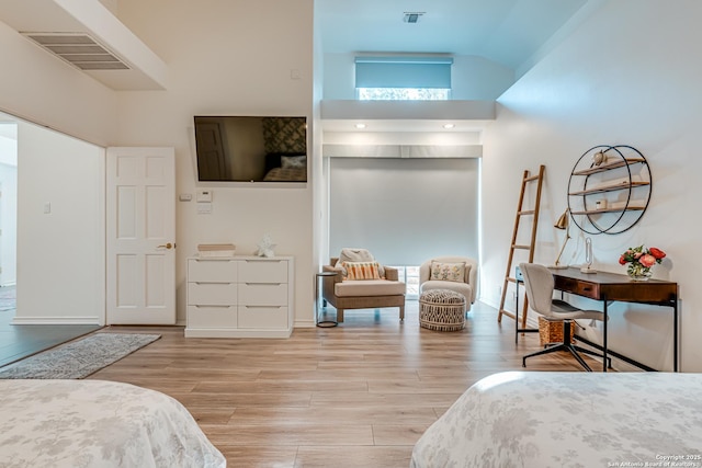 bedroom featuring light hardwood / wood-style floors and high vaulted ceiling