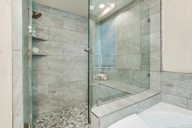 bathroom featuring shower with separate bathtub