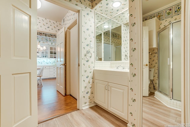 bathroom with vanity, wood-type flooring, and an enclosed shower