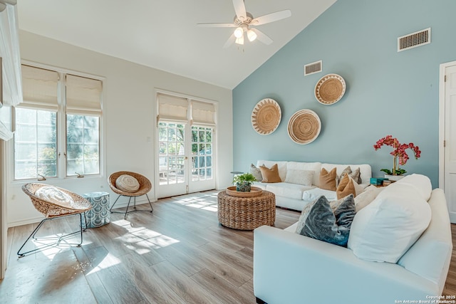 living room featuring ceiling fan, french doors, high vaulted ceiling, and light hardwood / wood-style floors