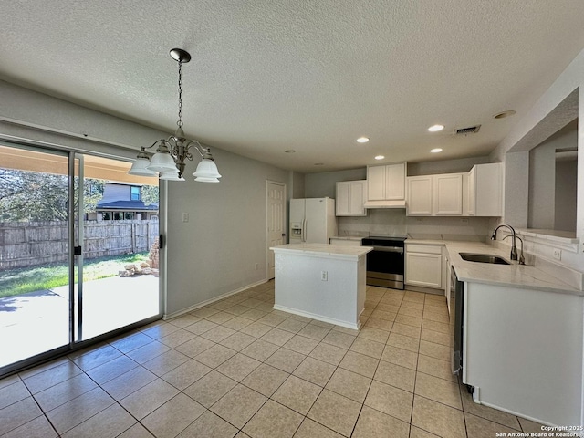 kitchen with pendant lighting, sink, a kitchen island, white cabinetry, and stainless steel appliances