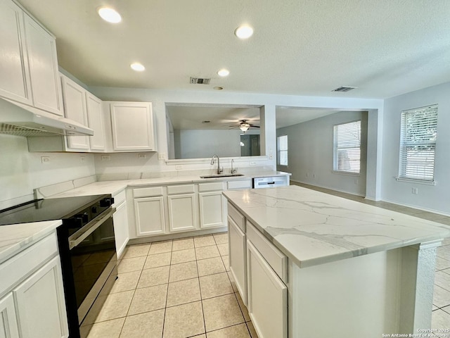 kitchen with sink, light tile patterned floors, white cabinets, a kitchen island, and stainless steel range with electric cooktop