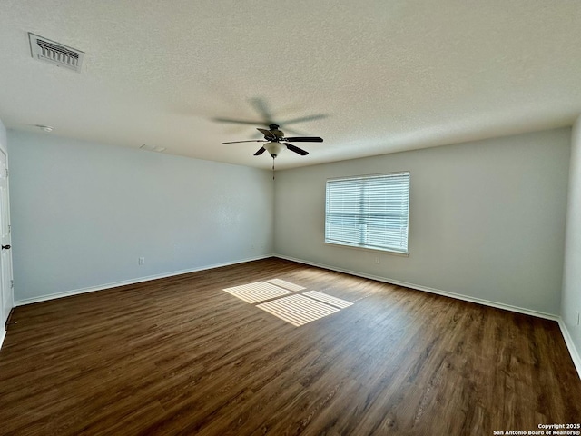 spare room with a textured ceiling, ceiling fan, and dark wood-type flooring