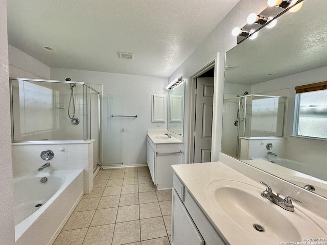 bathroom with vanity, a textured ceiling, tile patterned floors, and separate shower and tub