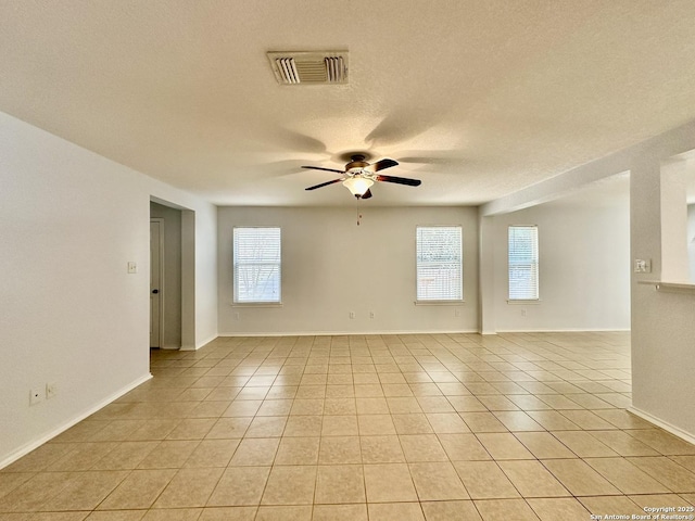 spare room with ceiling fan, light tile patterned flooring, and a textured ceiling