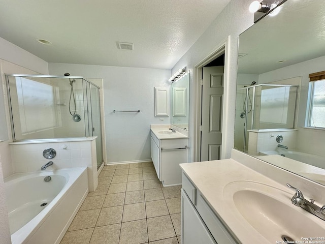 bathroom featuring tile patterned flooring, vanity, a textured ceiling, and plus walk in shower