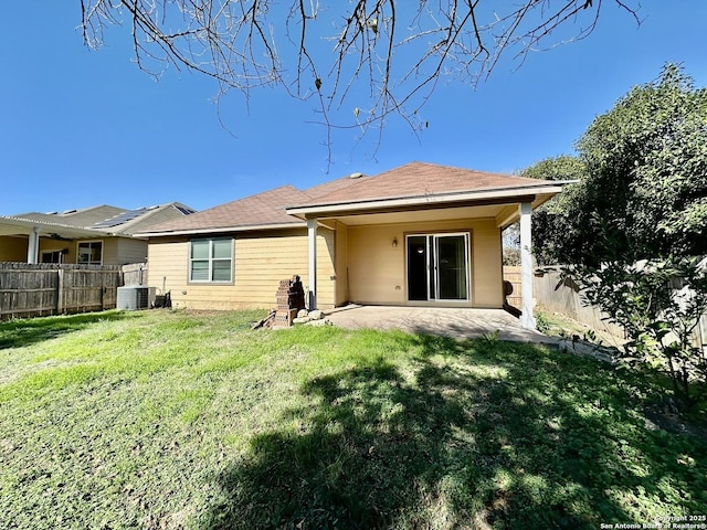 rear view of house with central AC, a patio area, and a yard