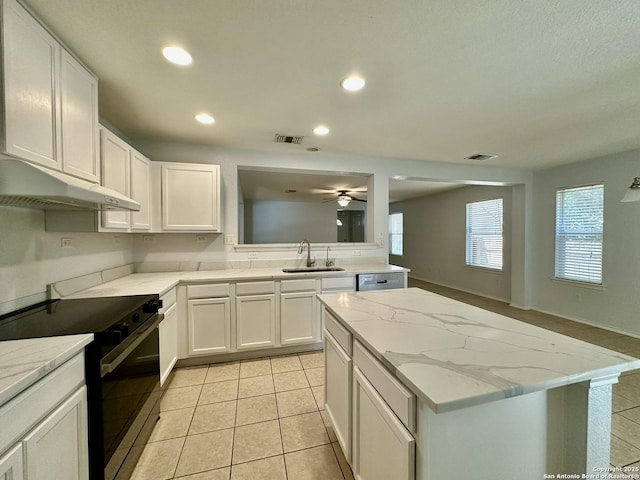 kitchen with light stone counters, stainless steel appliances, sink, white cabinets, and light tile patterned flooring