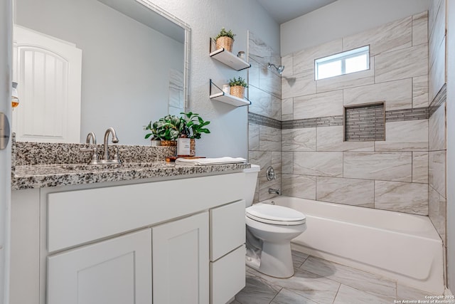 full bathroom featuring tiled shower / bath combo, toilet, and vanity