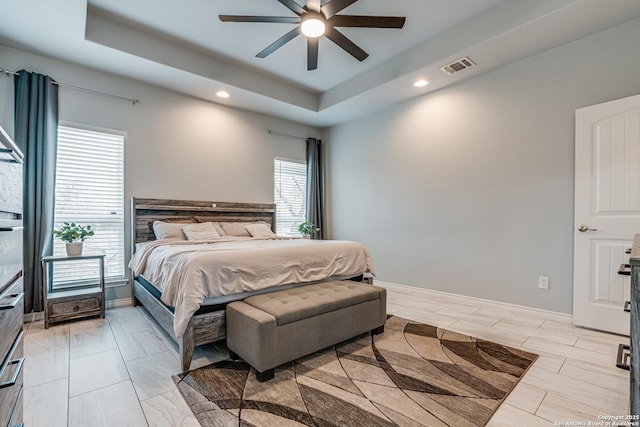 bedroom featuring a raised ceiling and ceiling fan