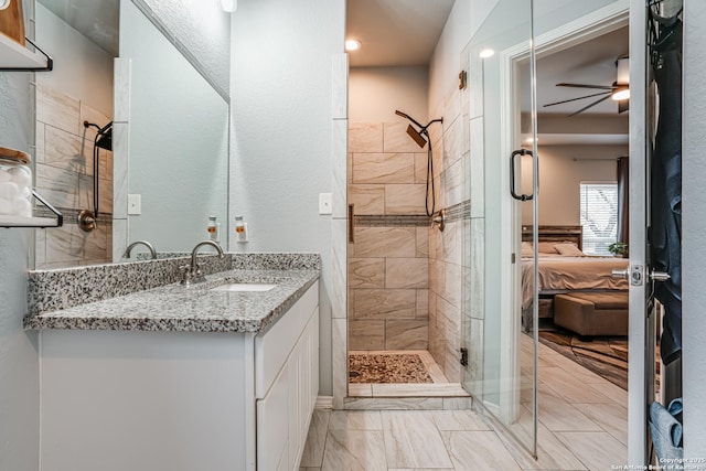 bathroom featuring ceiling fan, a shower with door, and vanity