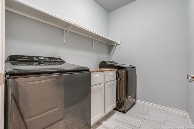 laundry room featuring cabinets and separate washer and dryer