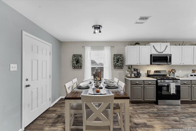 kitchen featuring gray cabinets, stainless steel appliances, white cabinetry, and dark wood-type flooring