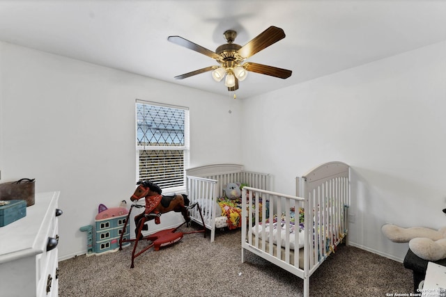 bedroom featuring carpet, ceiling fan, and a crib