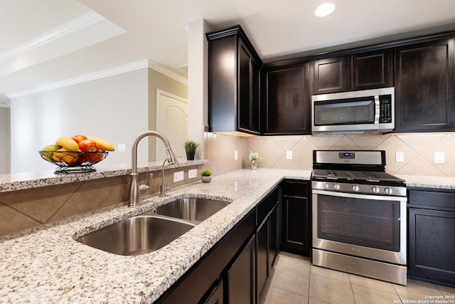 kitchen featuring appliances with stainless steel finishes, light stone counters, light tile patterned floors, and sink