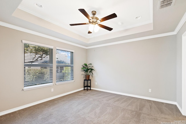 carpeted empty room with a raised ceiling, ceiling fan, and crown molding