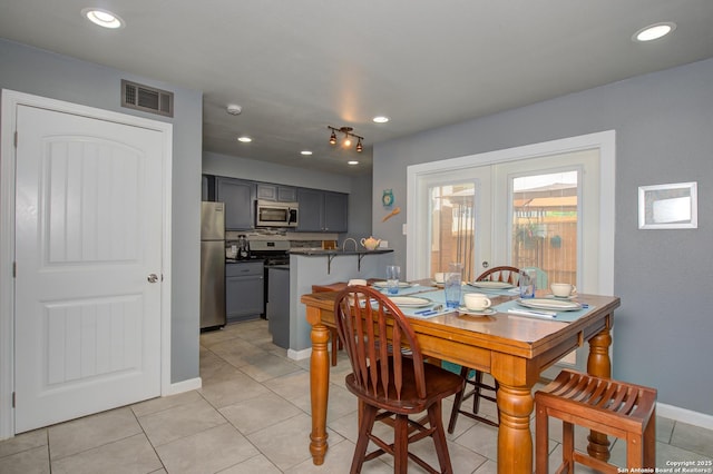 dining space with french doors and light tile patterned flooring