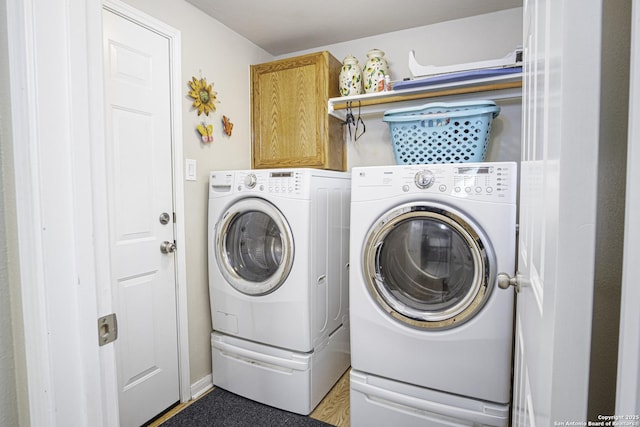 clothes washing area with cabinets and independent washer and dryer