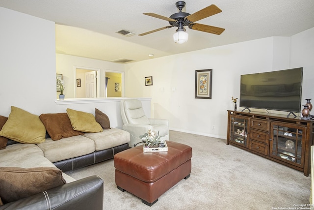 carpeted living room with a textured ceiling and ceiling fan