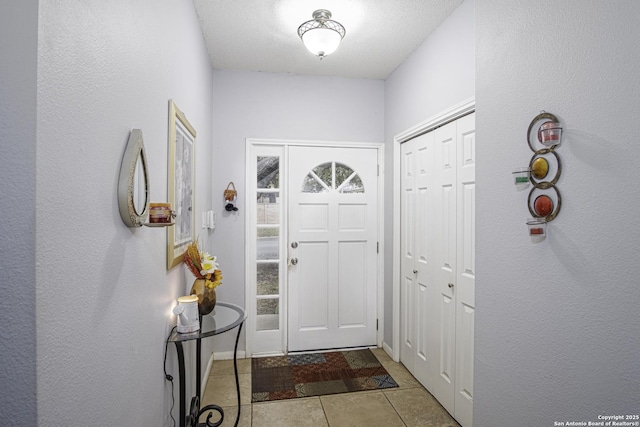 foyer featuring light tile patterned flooring and a textured ceiling