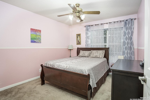 carpeted bedroom featuring ceiling fan and a textured ceiling