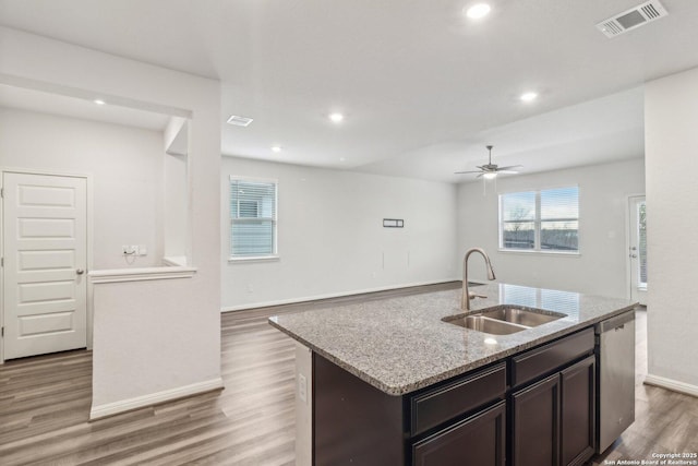 kitchen featuring ceiling fan, sink, a center island with sink, dishwasher, and hardwood / wood-style floors