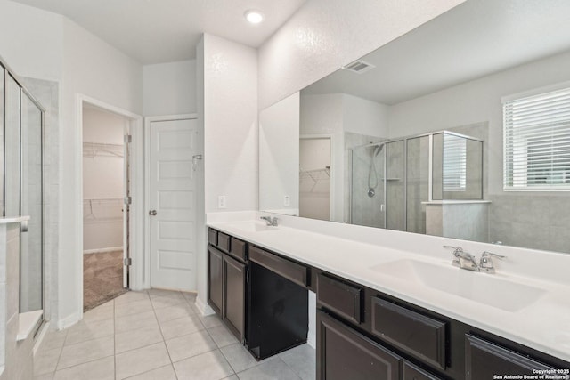 bathroom featuring tile patterned flooring, vanity, and walk in shower