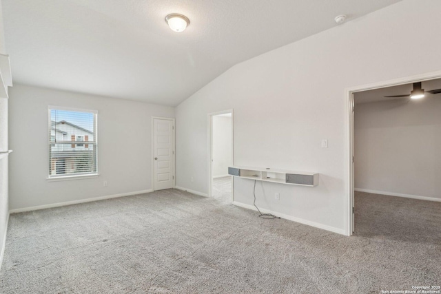 unfurnished living room featuring carpet floors, vaulted ceiling, and ceiling fan