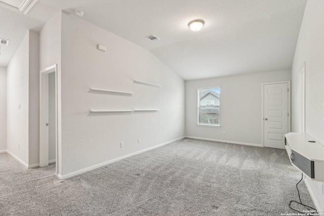 unfurnished living room featuring light carpet, a textured ceiling, and lofted ceiling