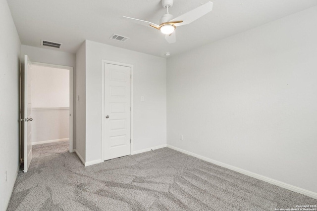 unfurnished bedroom with ceiling fan, light colored carpet, and a closet