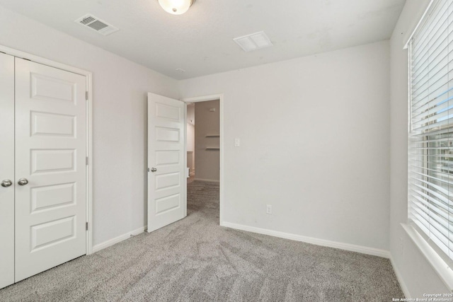 unfurnished bedroom with light carpet and a closet