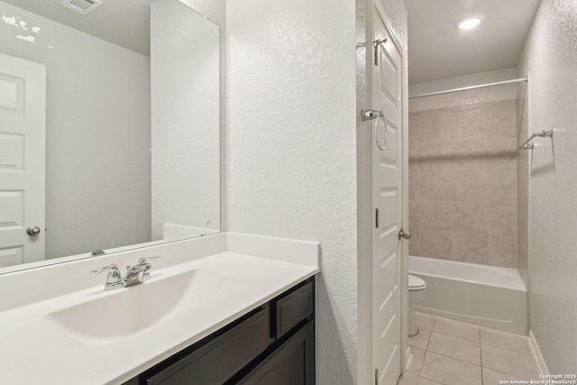 full bathroom with toilet, vanity, tile patterned floors, and tiled shower / bath combo