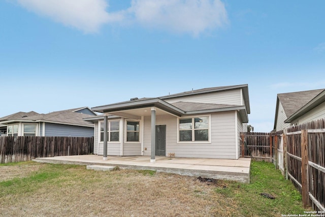 rear view of property featuring a lawn and a patio area