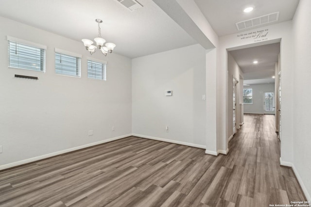 unfurnished room featuring hardwood / wood-style flooring and a notable chandelier