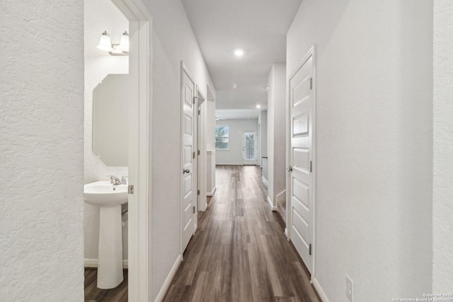 corridor with dark hardwood / wood-style floors and sink