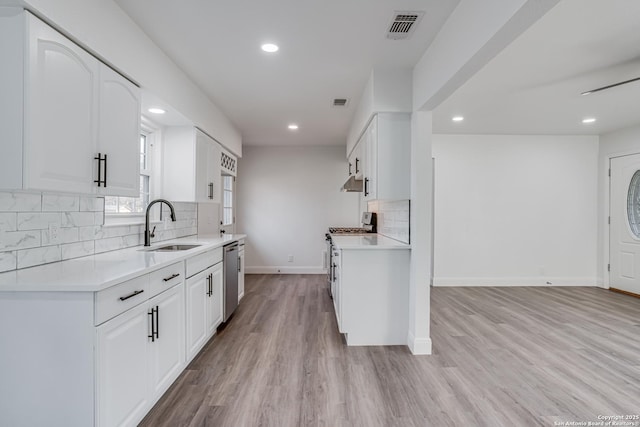 kitchen featuring stainless steel appliances, white cabinets, and light wood-type flooring