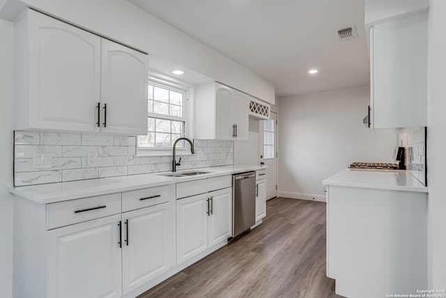 kitchen featuring range, dishwasher, and white cabinets