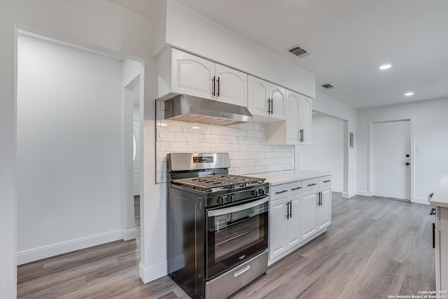 kitchen with tasteful backsplash, white cabinetry, stainless steel range with gas stovetop, and light hardwood / wood-style flooring