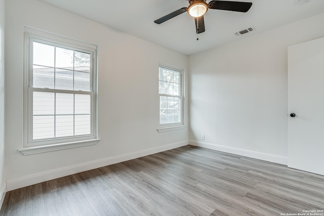 empty room with ceiling fan and light hardwood / wood-style floors