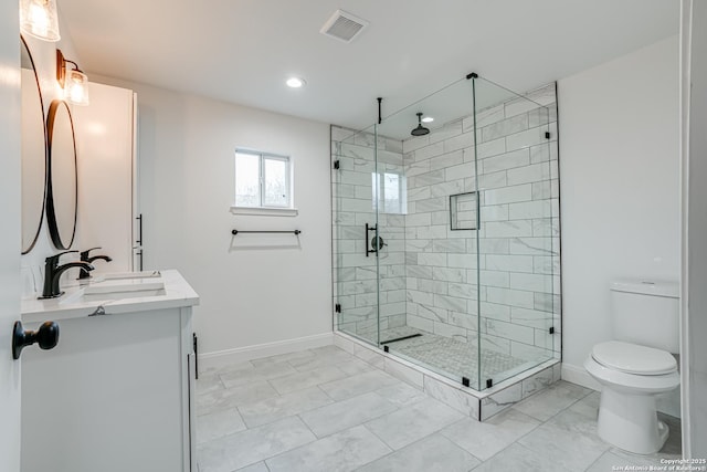 bathroom featuring vanity, toilet, and a shower with shower door