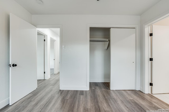 unfurnished bedroom with light hardwood / wood-style floors and a closet