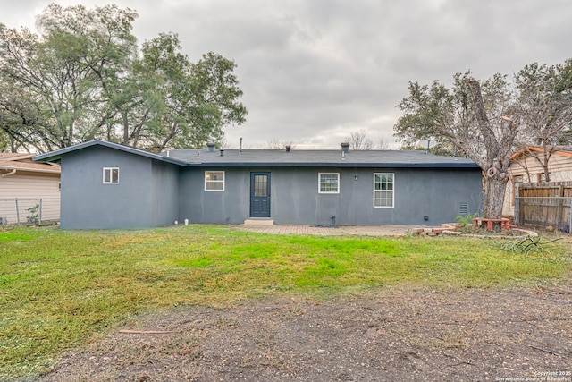 rear view of house featuring a yard